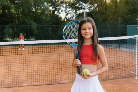 child-playing-tennis-on-outdoor-court-little-girl-2024-01-23-18-54-05-utc-scaled-1